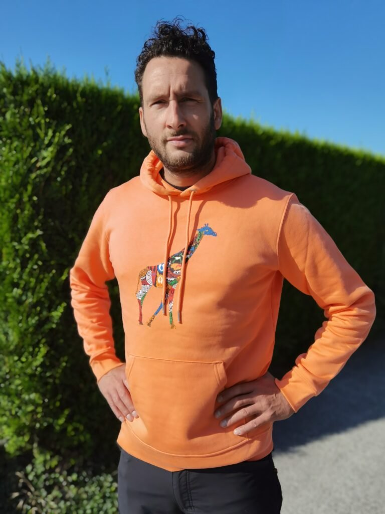 Sweat orange motif girafe porté sur un homme européen de la marque de streetwear afro pamoja