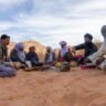 group of people sitting on sand