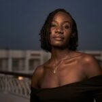 A woman standing on a bridge at night